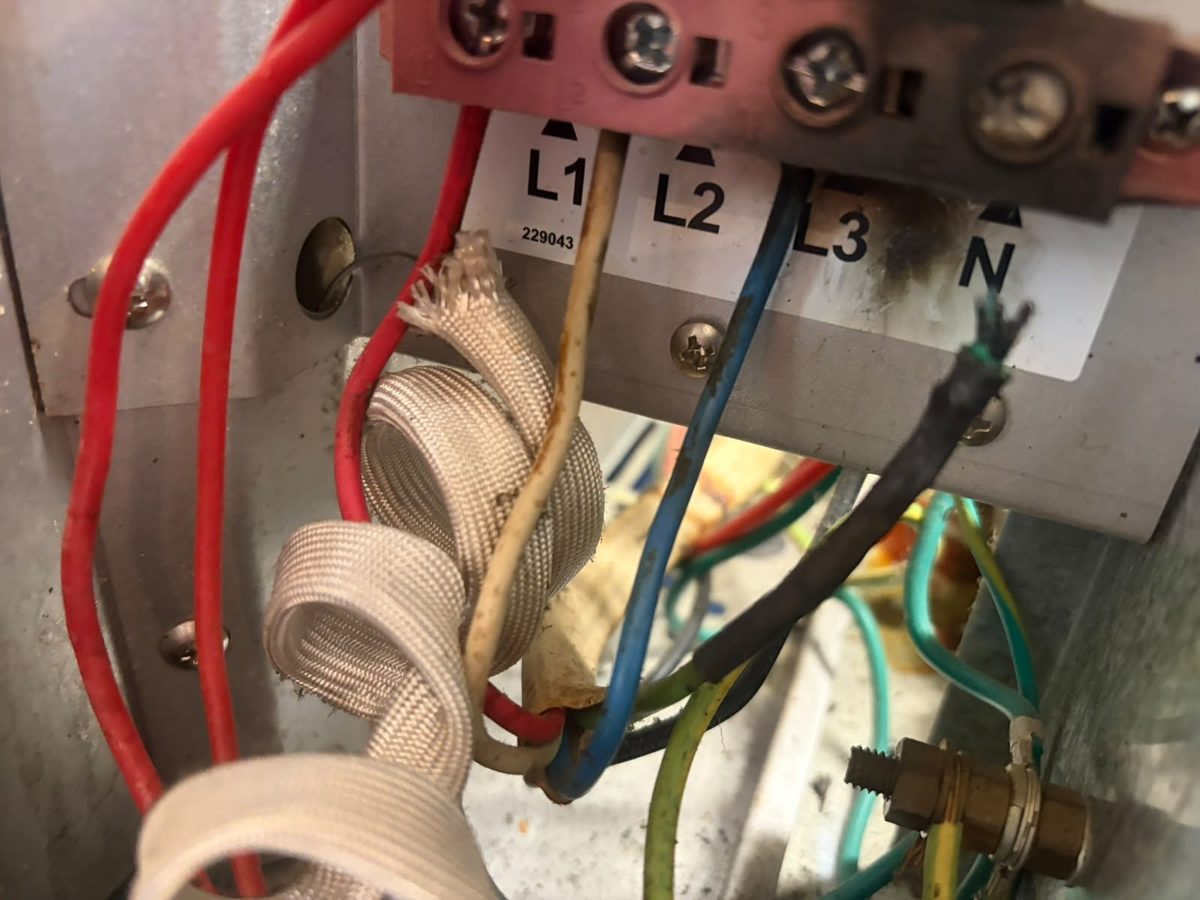 Burnt three-phase terminal block and damaged neutral cable found inside a commercial appliance