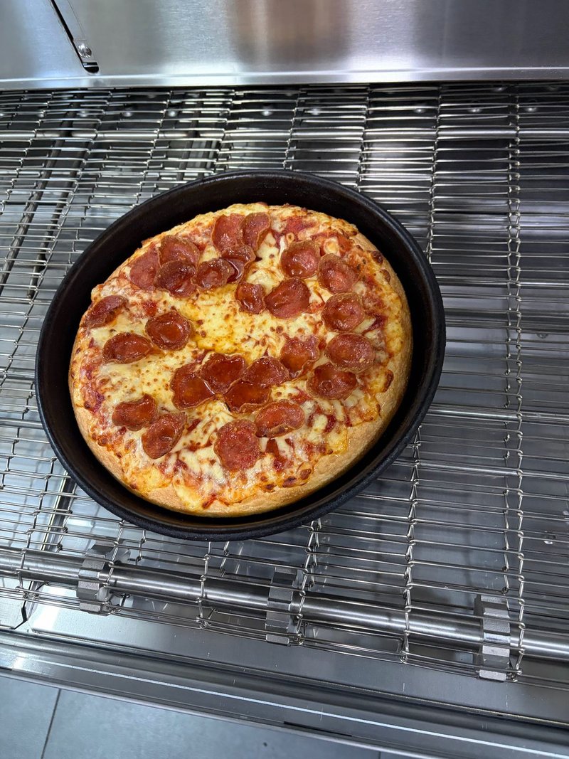 Pepperoni pan pizza coming off the conveyor of a new XLT gas oven