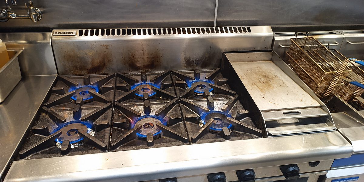 Commercial gas range with six burners and griddle