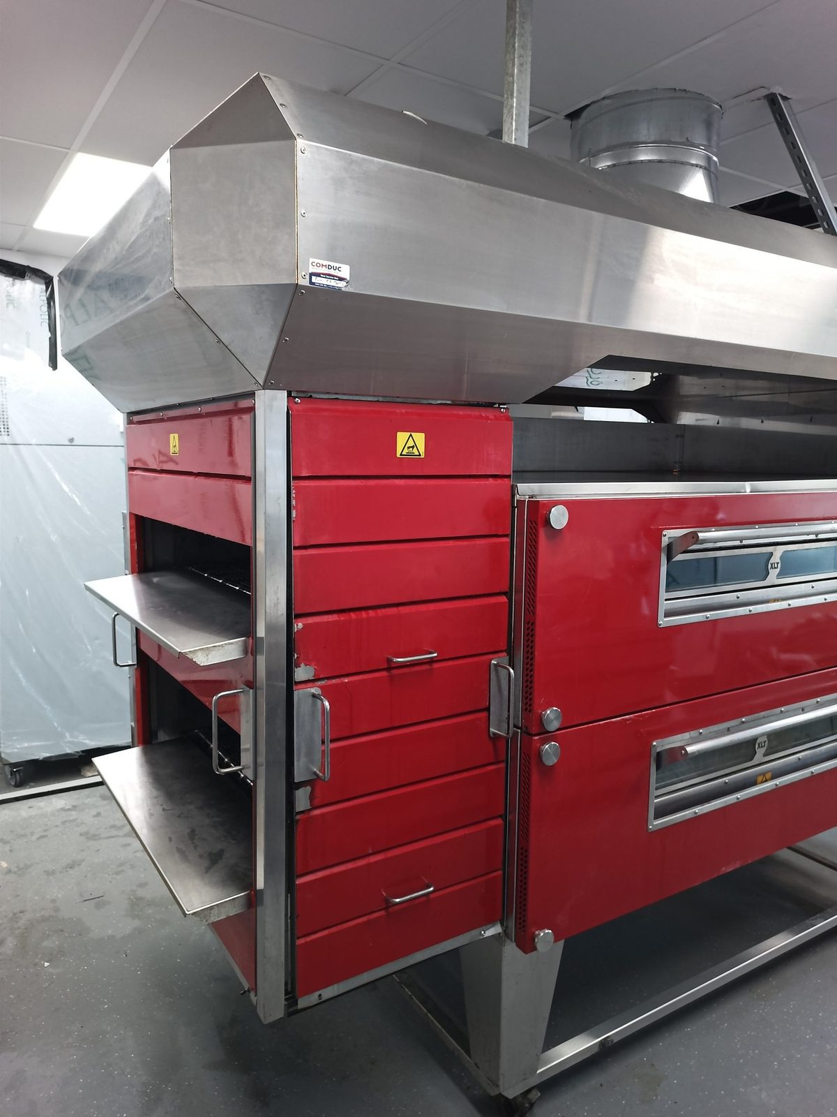Conveyor pizza oven under an extraction hood