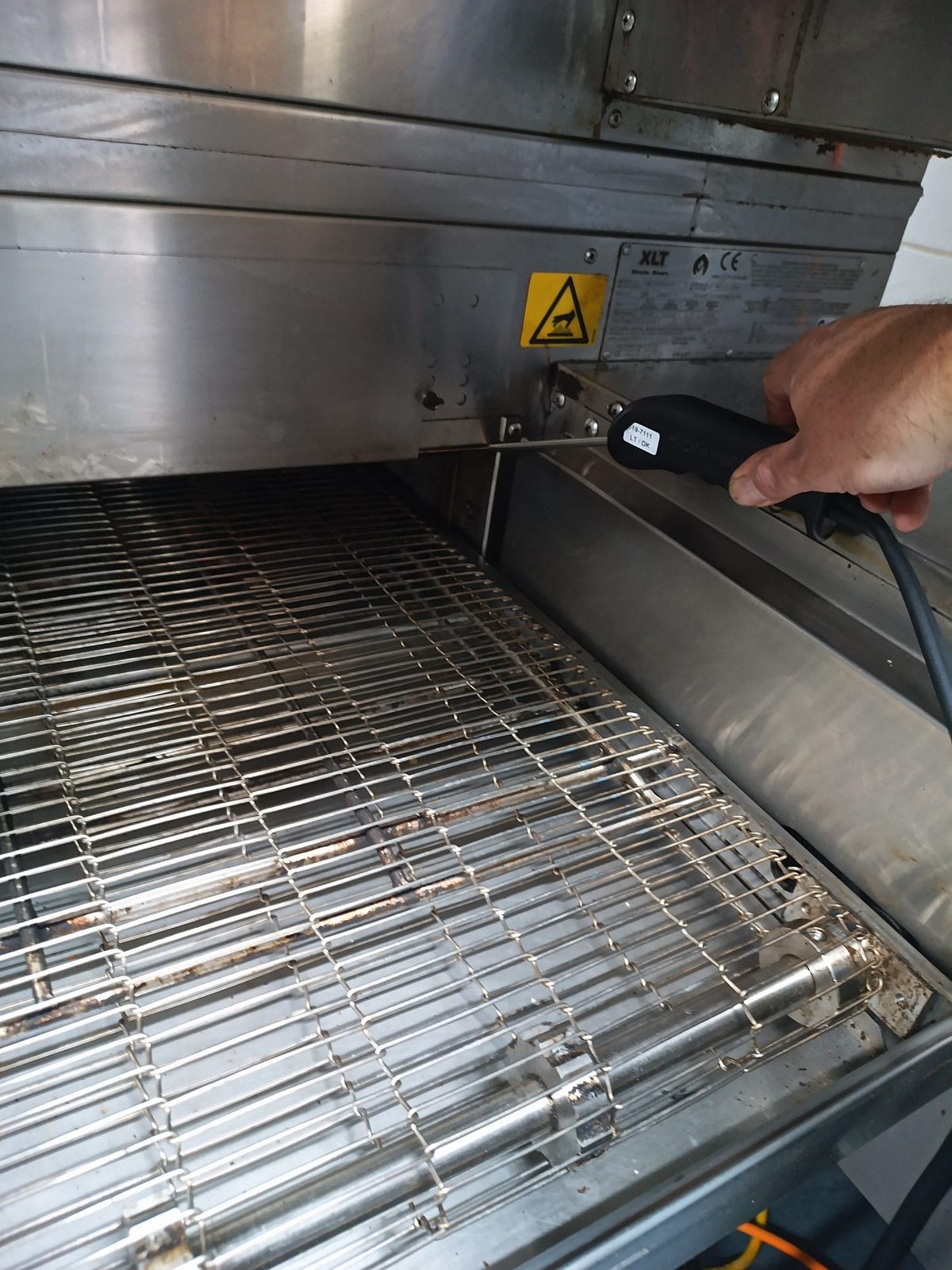CES Wellington factory-trained technician servicing a conveyor pizza oven