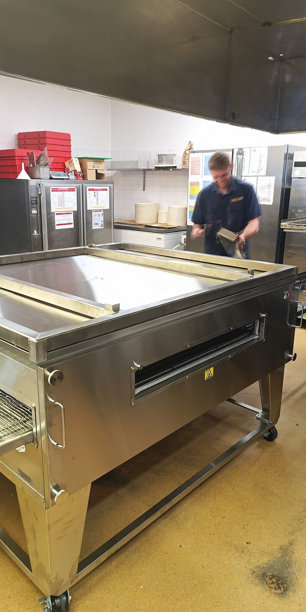 CES Wellington factory-trained technician working behind a commercial oven