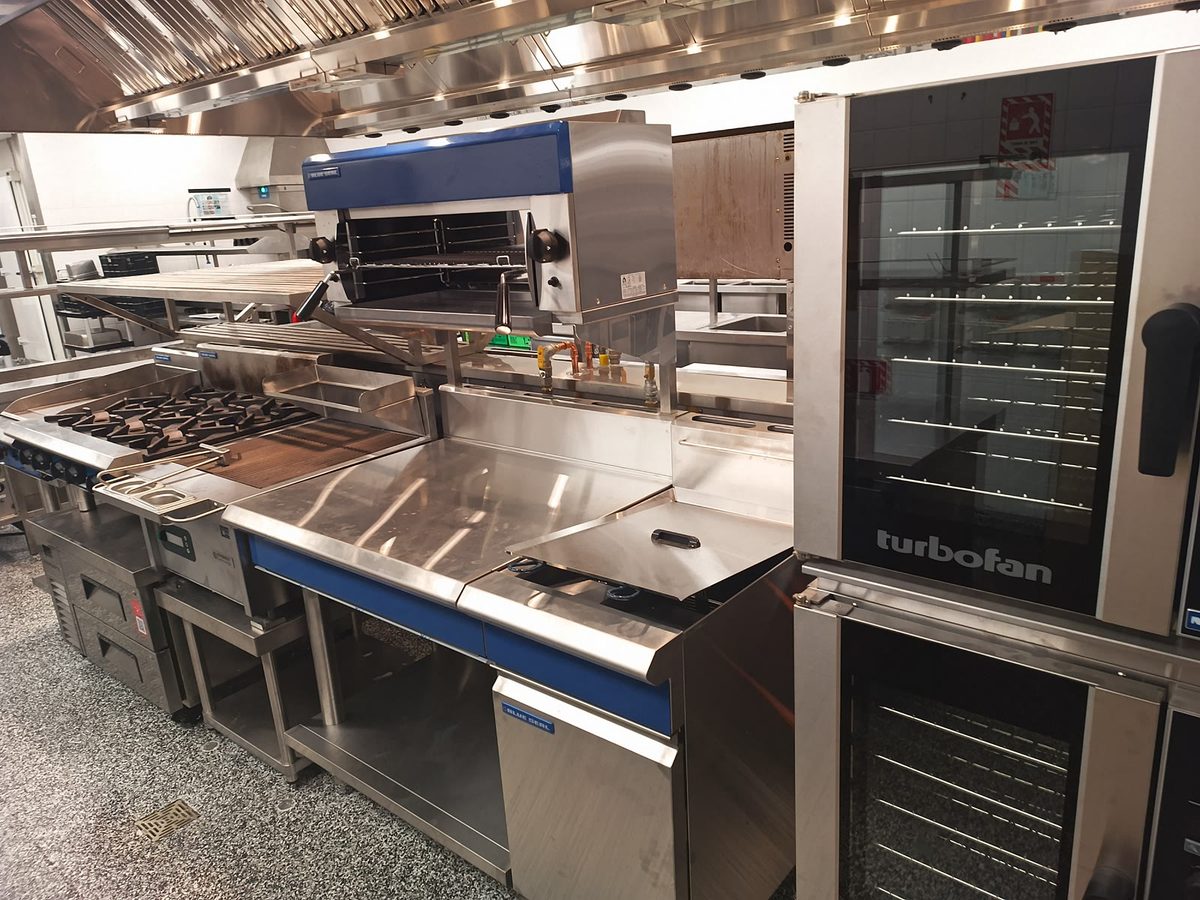 Blue Seal Turbofan convection ovens stacked beside a fryer on a commercial cookline