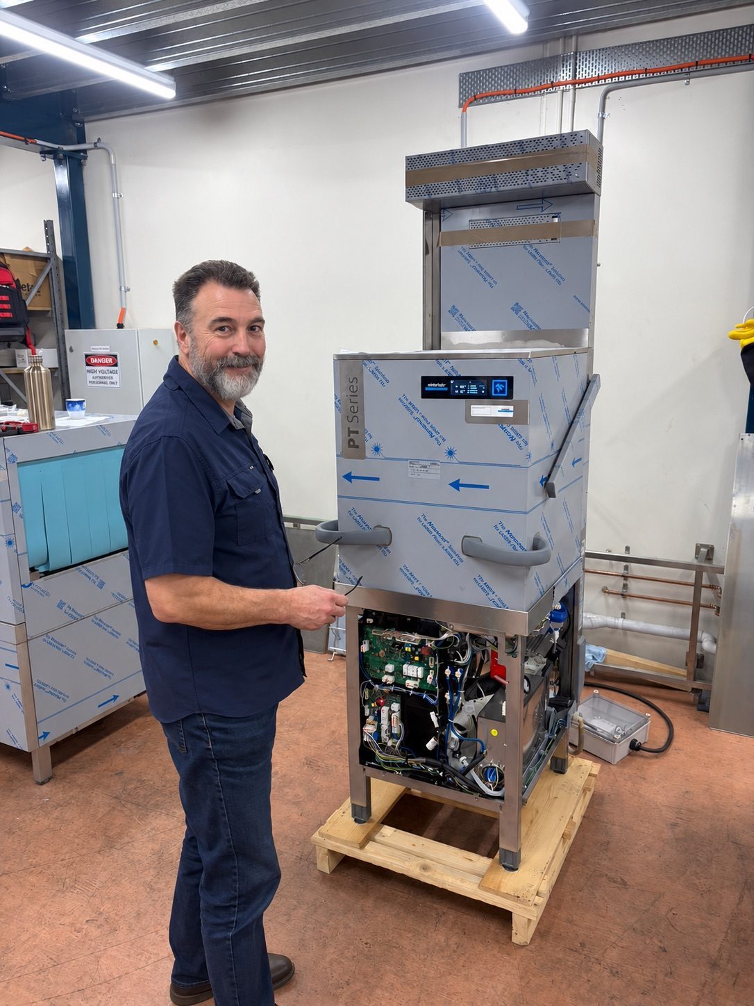 Technician with a Winterhalter PT Series pass-through dishwasher in the CESW workshop